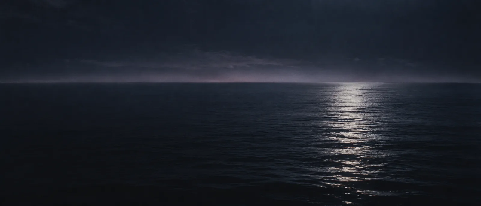 Moonlight reflecting on a calm dark sea at night